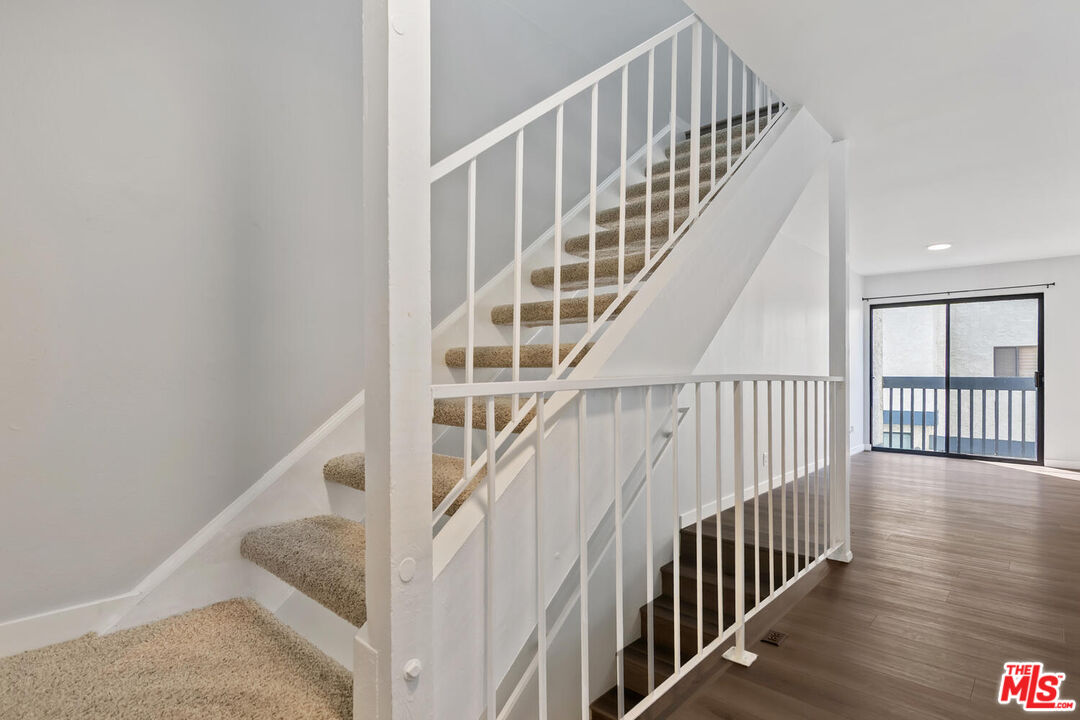 29239 Heathercliff Road, Unit 12 Malibu, CA 90265 - Photo 17 of 32 a view of staircase with wooden floor and white walls