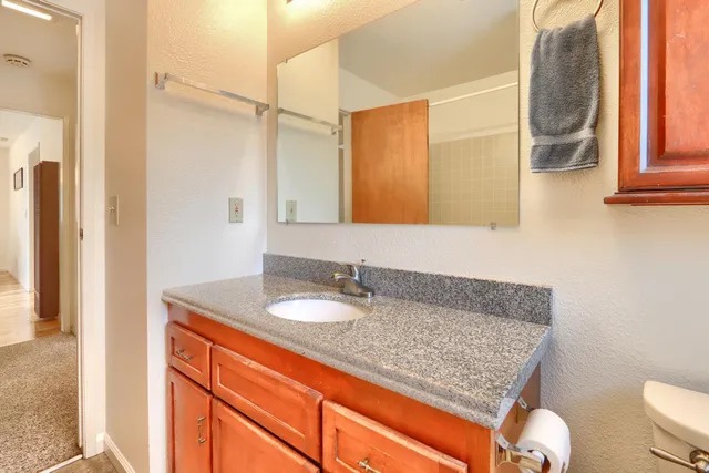 a bathroom with a granite countertop sink and a mirror