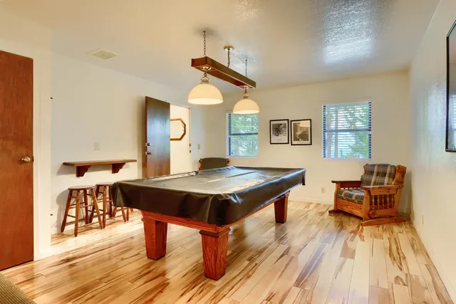 a living room with table chairs and a wooden floor