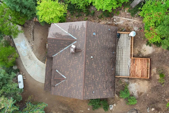 an aerial view of a house with a yard and large trees