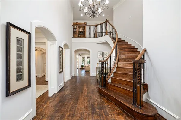 a view of a hallway with dining room and wooden floor
