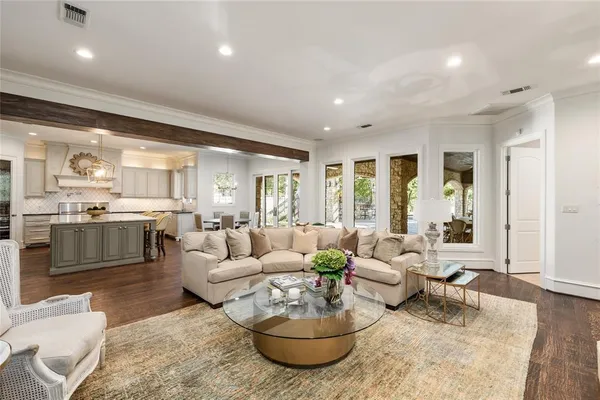 a kitchen with stainless steel appliances granite countertop a sink a stove a refrigerator and island with wooden floor