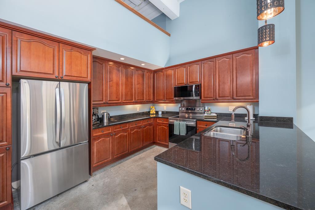 1201 Front Avenue, Unit 222 Columbus, GA 31901 - Photo 16 of 29 a kitchen with stainless steel appliances granite countertop a refrigerator stove microwave and sink