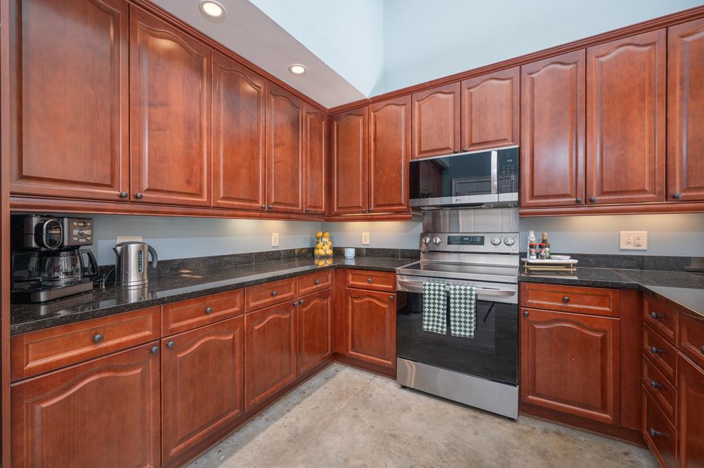 1201 Front Avenue, Unit 222 Columbus, GA 31901 - Photo 18 of 29 a kitchen with granite countertop wooden cabinets stainless steel appliances and a sink