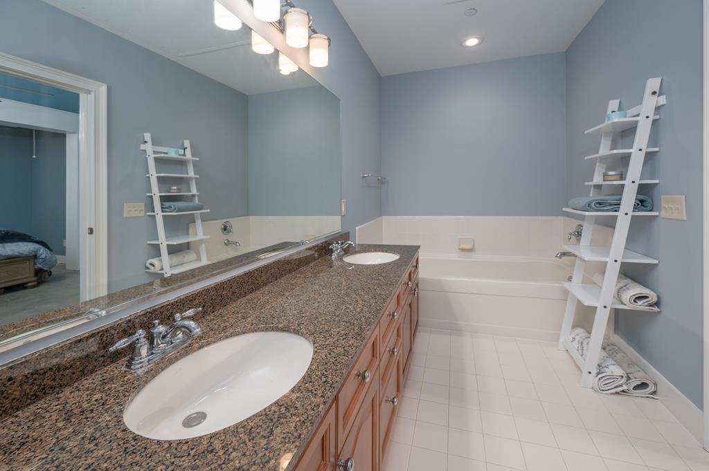 1201 Front Avenue, Unit 222 Columbus, GA 31901 - Photo 26 of 29 a bathroom with a granite countertop sink a mirror and a bathtub
