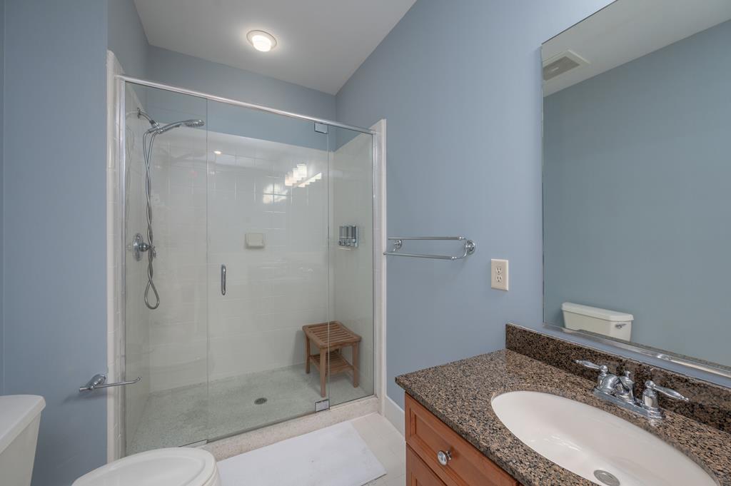 1201 Front Avenue, Unit 222 Columbus, GA 31901 - Photo 27 of 29 a bathroom with a granite countertop sink a mirror and a shower