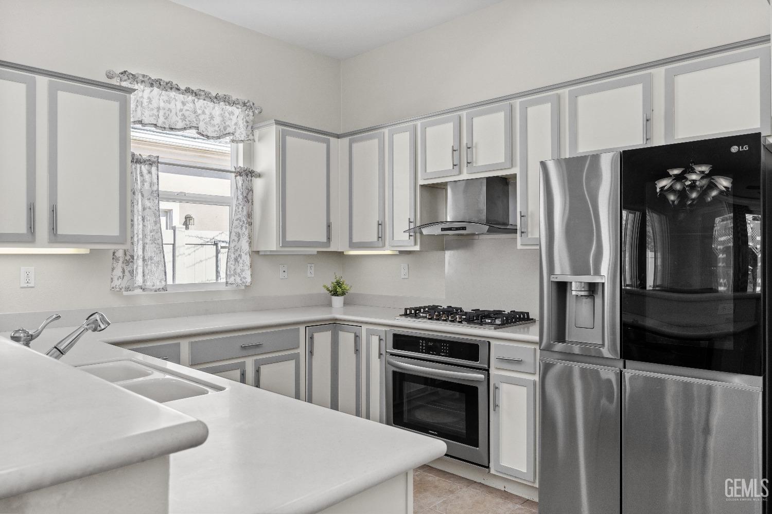 Undisclosed Address Bakersfield, CA 93306 - Photo 11 of 24 a kitchen with stainless steel appliances a stove sink and refrigerator