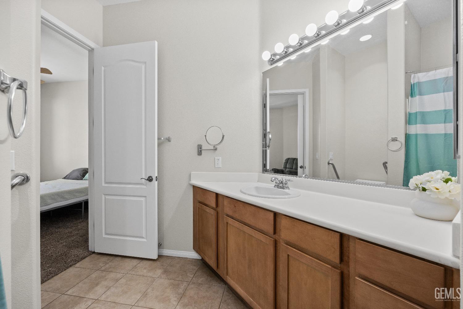 Undisclosed Address Bakersfield, CA 93306 - Photo 19 of 24 a spacious bathroom with a granite countertop sink and a mirror