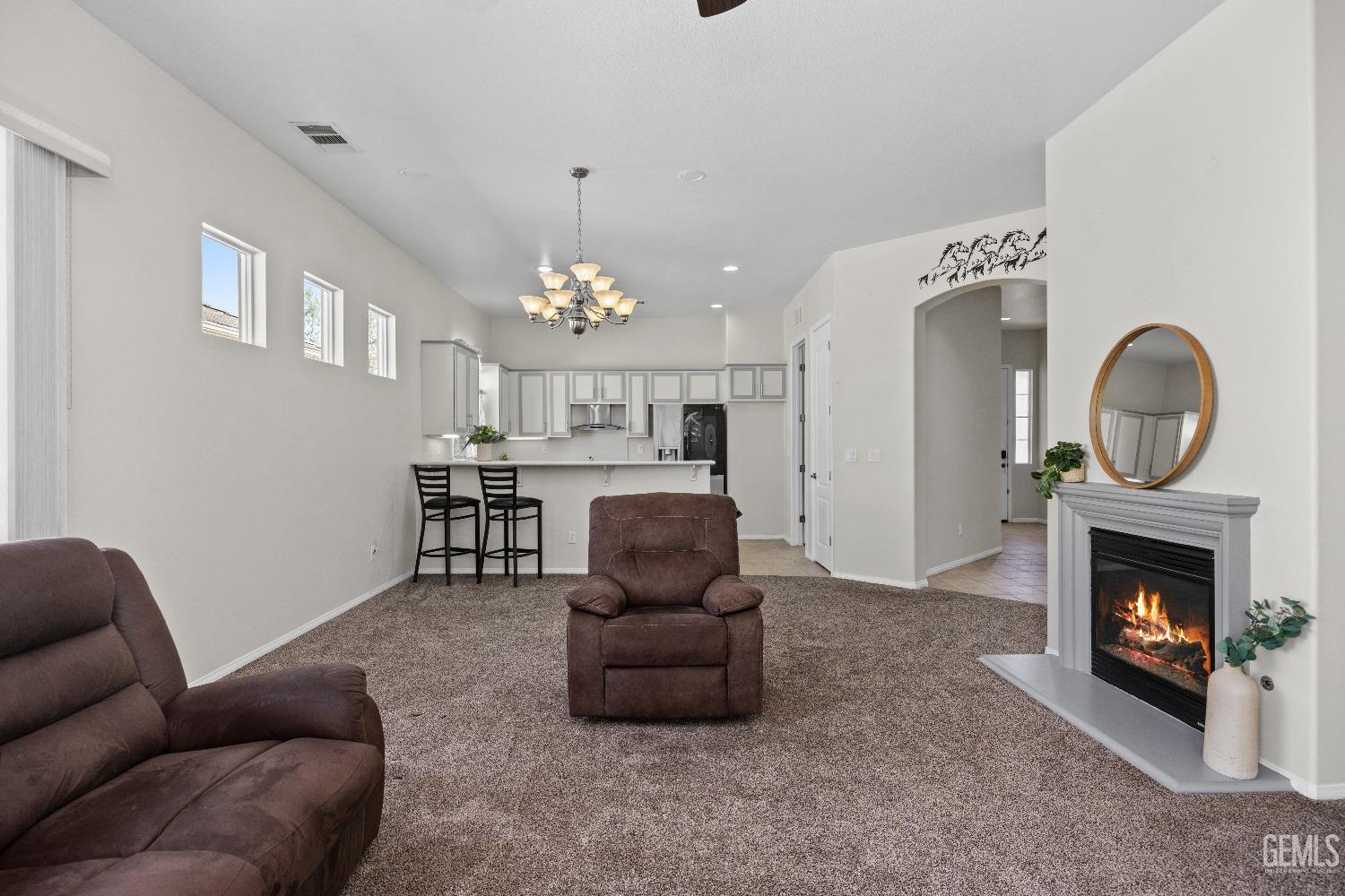 Undisclosed Address Bakersfield, CA 93306 - Photo 8 of 24 a living room with furniture a fireplace and a chandelier