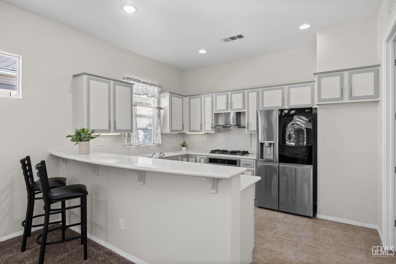 Undisclosed Address Bakersfield, CA 93306 - Photo 10 of 24 a kitchen with a sink a refrigerator and chairs