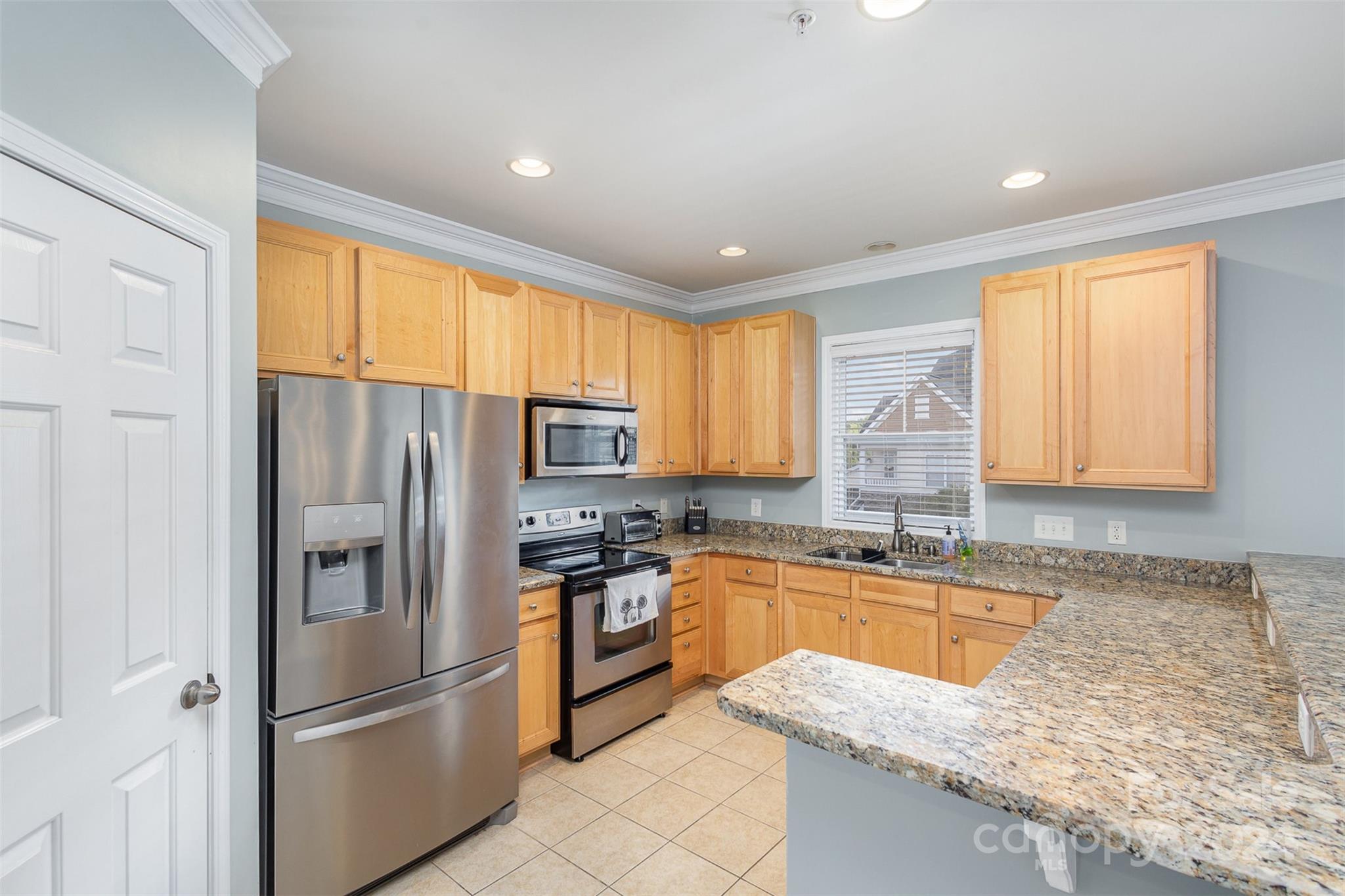 311 Wave Crest Drive Fort Mill, SC 29708 - Photo 9 of 45 a kitchen with granite countertop stainless steel appliances a refrigerator sink microwave and cabinets