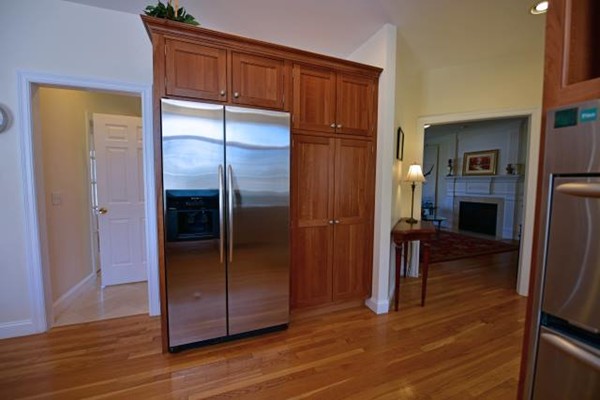 102 Argilla Road Andover, MA 01810 - Photo 12 of 30 a view of a refrigerator in kitchen and an empty room with wooden floor