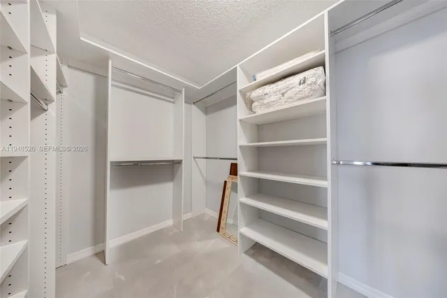 a view of walk in closet with empty racks