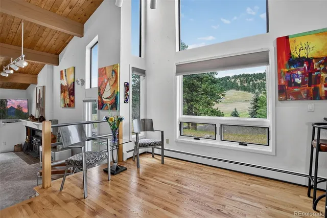 a living room with furniture a flat screen tv and floor to ceiling window