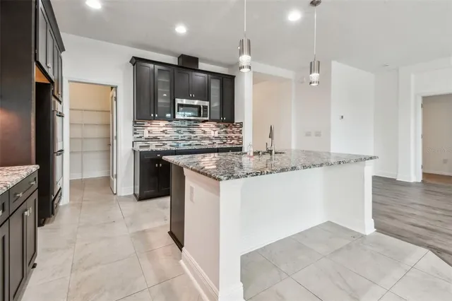 a kitchen with stainless steel appliances granite countertop a sink and a stove top oven