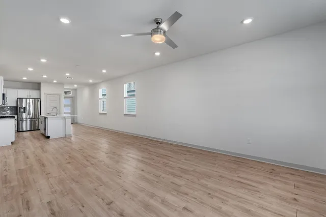 a view of a livingroom with a kitchen counter top space cabinets and appliances