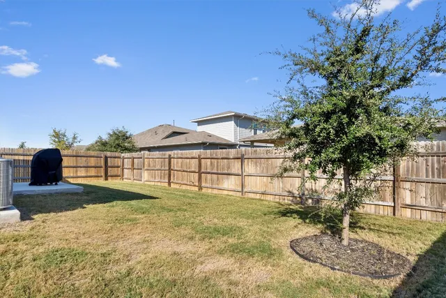 a backyard of a house with table and chairs