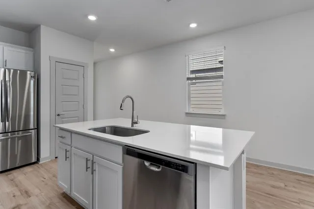 a kitchen with refrigerator a stove a sink and a microwave