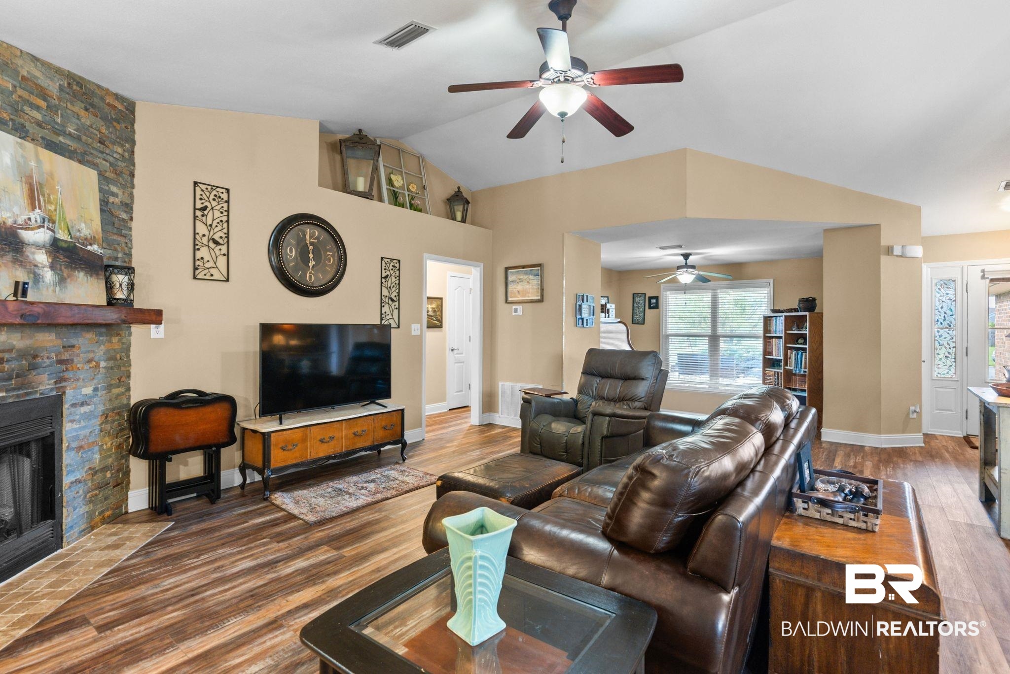 562 Vestige Mews Foley, AL 36535 - Photo 8 of 54 Vaulted living area featuring wood-finish flooring and a stacked stone fireplace with a wood mantle