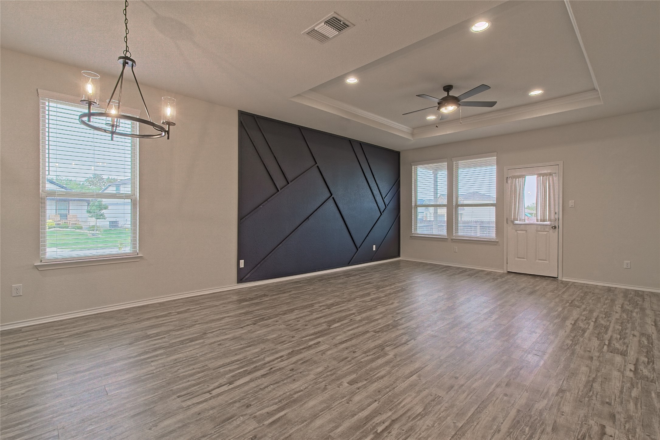 601 Hummingbird Lane Leander, TX 78641 - Photo 15 of 35 Unfurnished room with ceiling fan, dark wood-type flooring, a barn door, recessed lighting, and a raised ceiling
