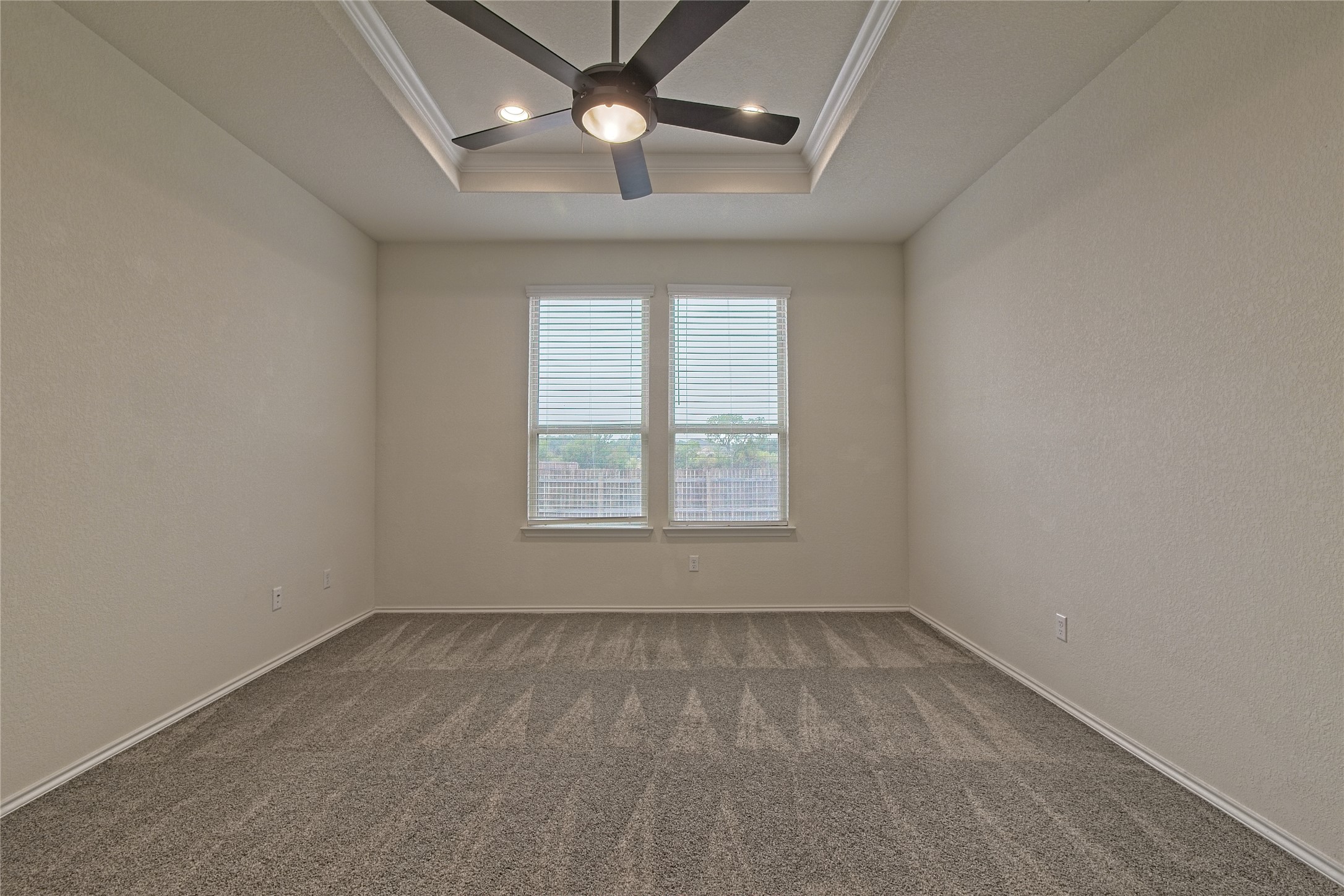 601 Hummingbird Lane Leander, TX 78641 - Photo 16 of 35 Unfurnished room with ornamental molding, a ceiling fan, dark colored carpet, a textured wall, and a raised ceiling