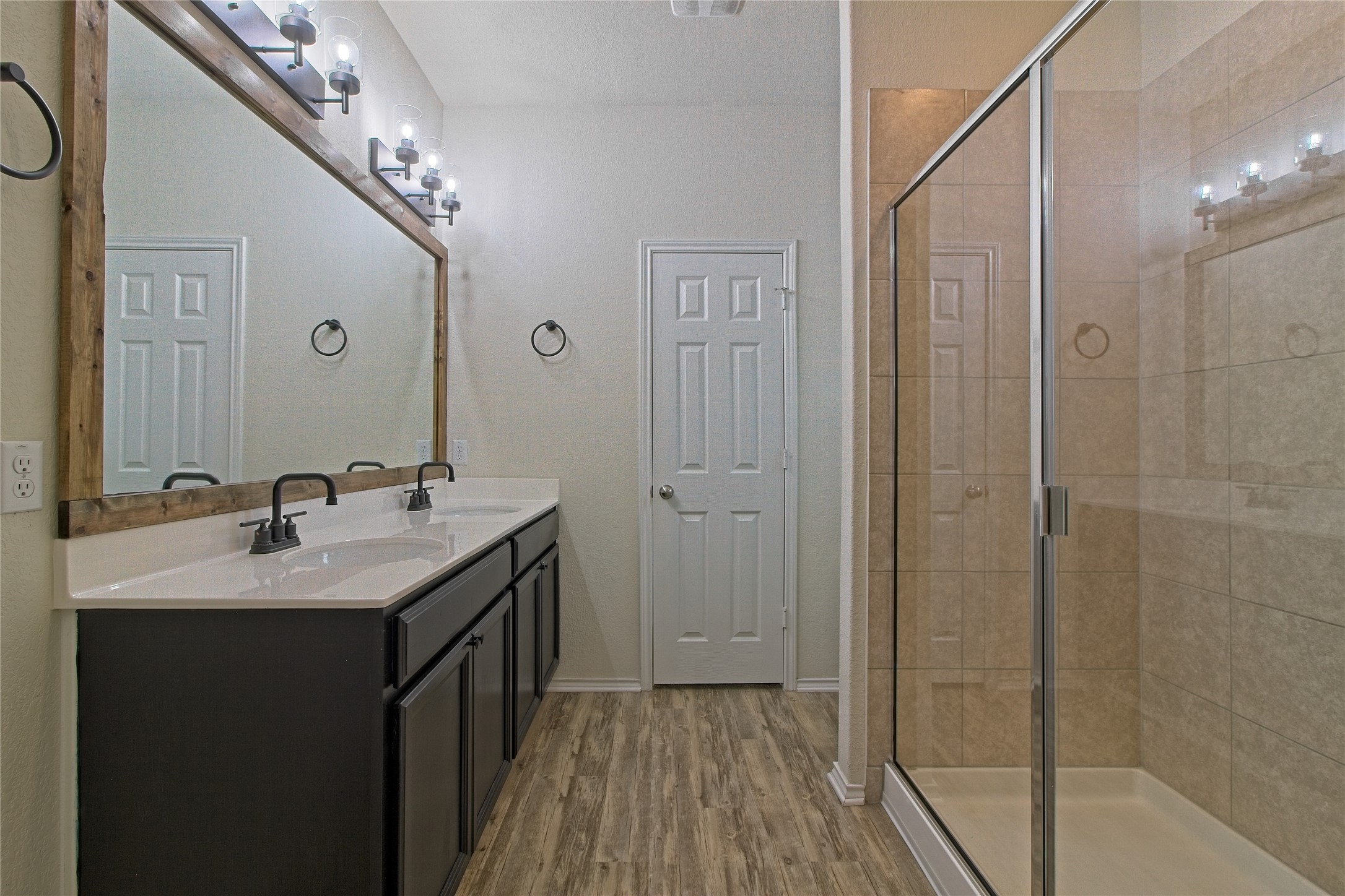 601 Hummingbird Lane Leander, TX 78641 - Photo 18 of 35 Full bathroom featuring double vanity, a stall shower, and light wood-type flooring