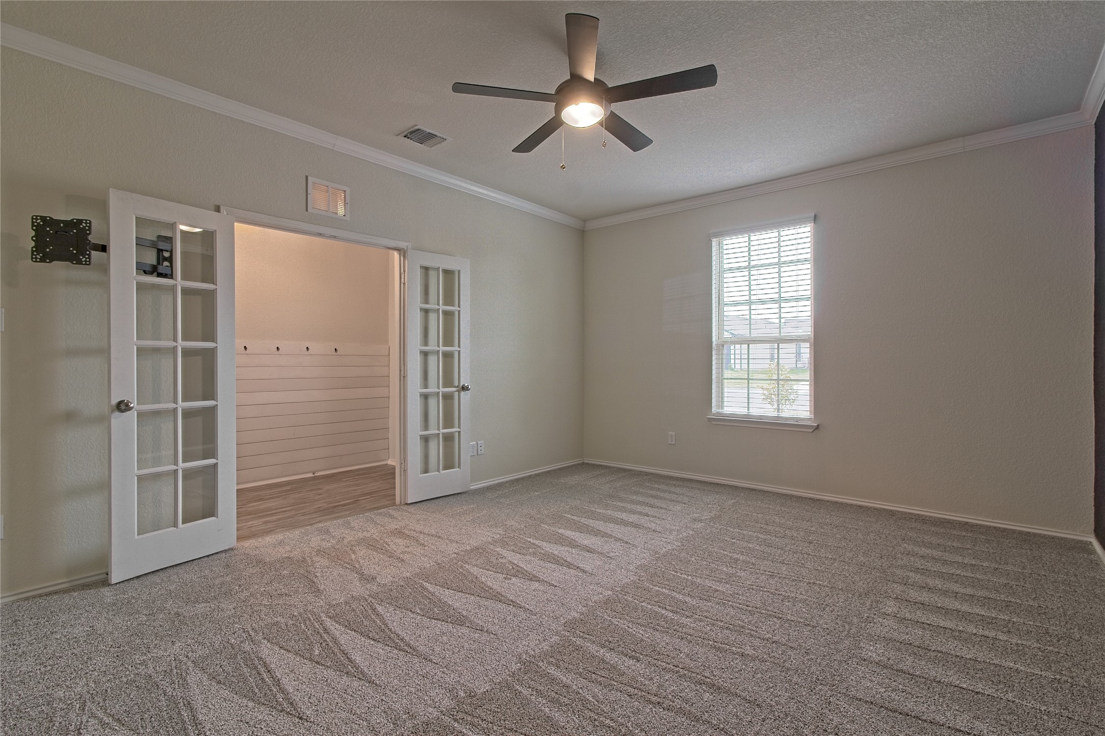 601 Hummingbird Lane Leander, TX 78641 - Photo 7 of 35 Carpeted spare room with french doors, a ceiling fan, crown molding, and a textured ceiling