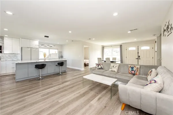a living room with furniture and view of kitchen