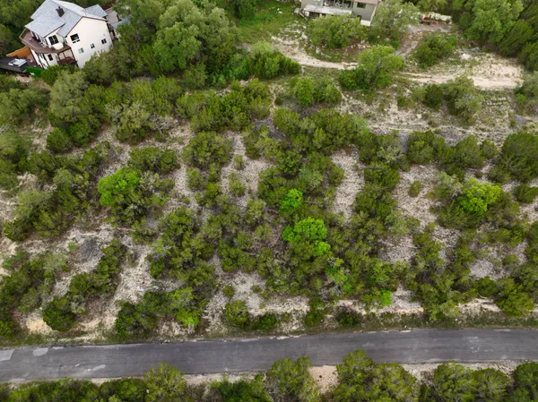 an aerial view of a house with a yard and lake view