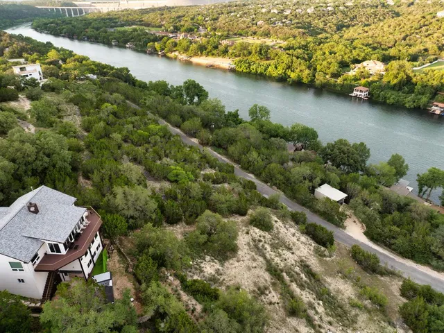an aerial view of a house with a garden and lake view