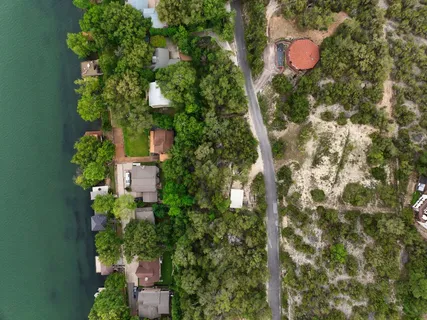 an aerial view of residential house with outdoor space and trees all around
