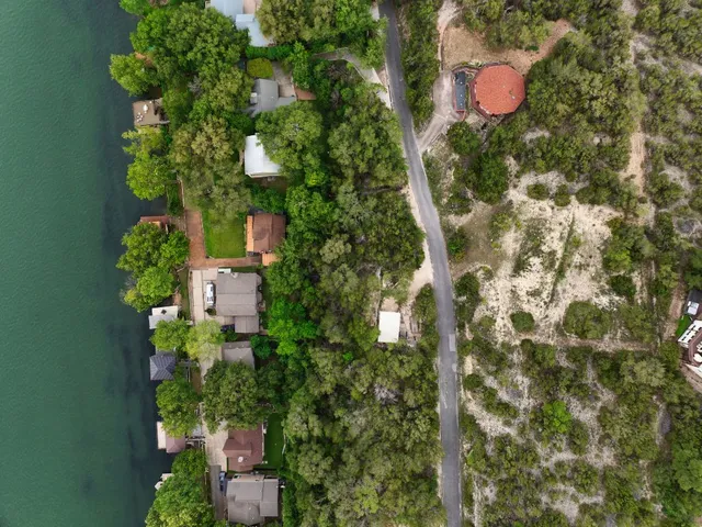an aerial view of residential house with outdoor space and trees all around
