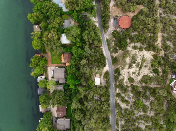 an aerial view of residential house with outdoor space and trees all around