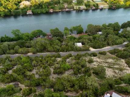 an aerial view of a house with a yard and lake view