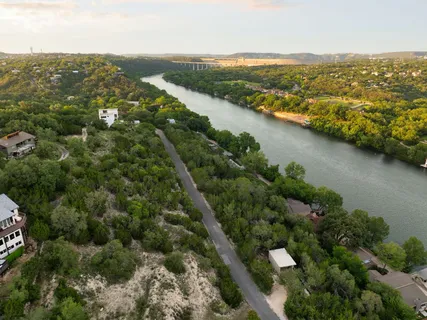 an aerial view of residential houses with outdoor space and trees