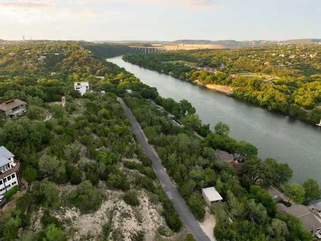 an aerial view of residential houses with outdoor space and trees