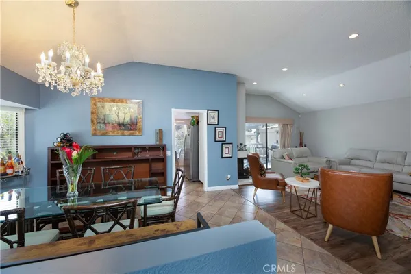 a living room with furniture a chandelier and a flat screen tv