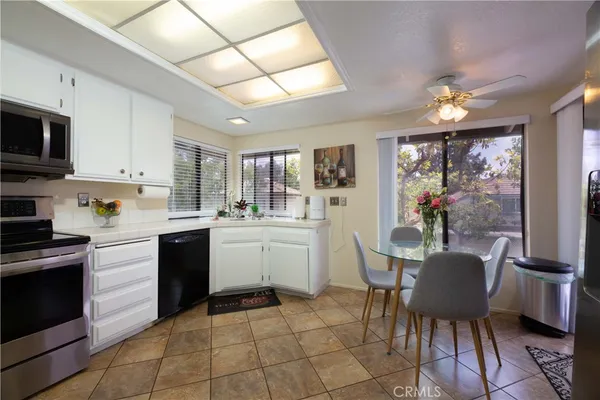 a kitchen with a table chairs microwave and cabinets