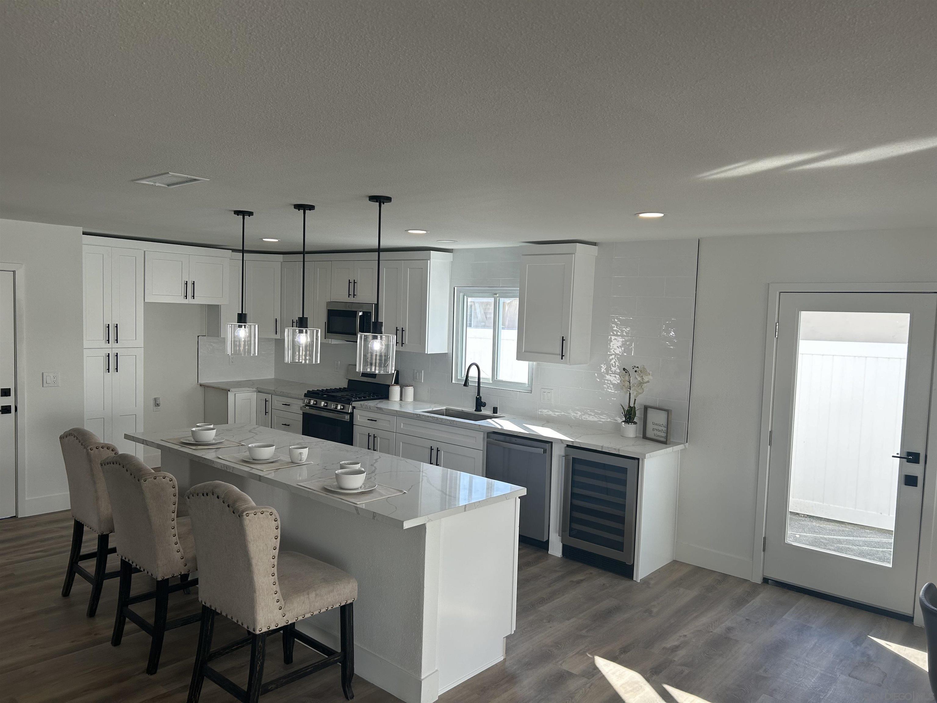 a large kitchen with kitchen island a sink table and chairs