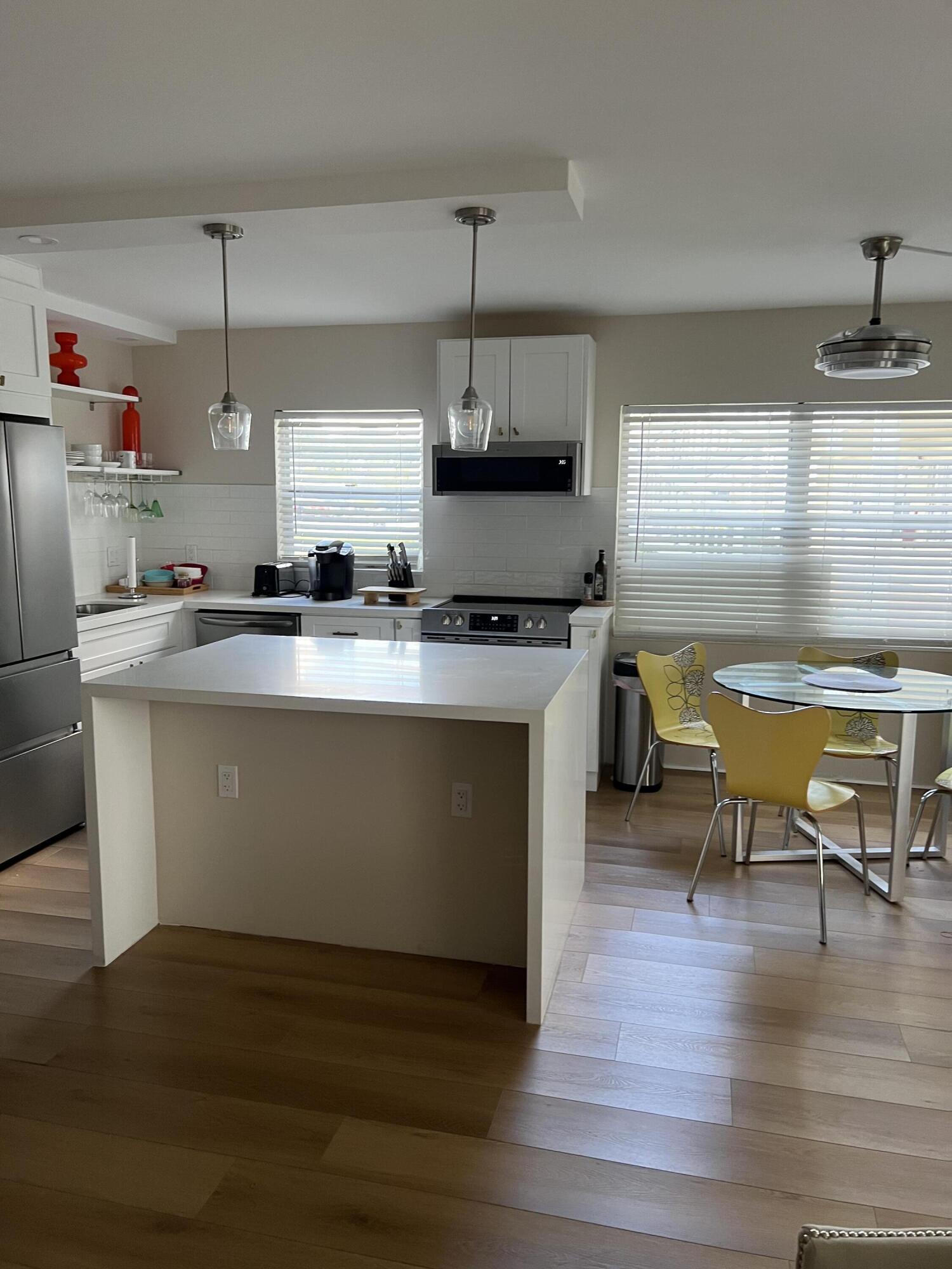 a kitchen with stainless steel appliances granite countertop a sink a stove and a wooden floors