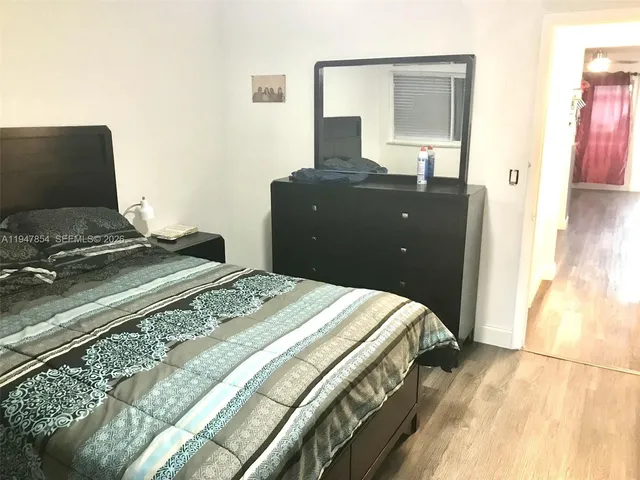 a bedroom with a bed and dresser with mirror