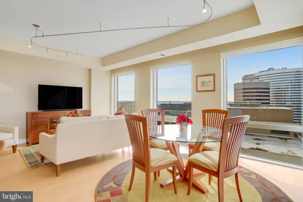 a living room with furniture kitchen view and a flat screen tv