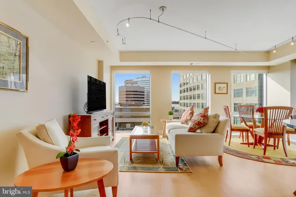 a living room with furniture kitchen view and a large window