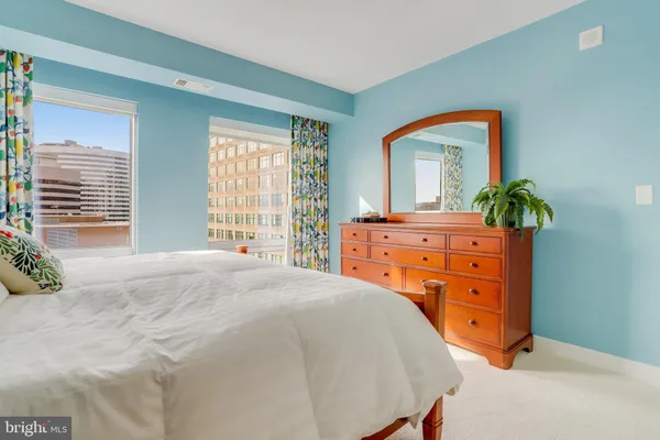 a bedroom with a bed and a large mirror on dresser