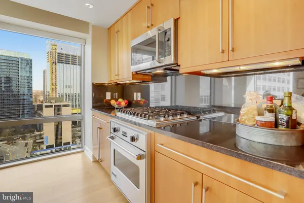a kitchen with stainless steel appliances granite countertop a stove a sink and a microwave