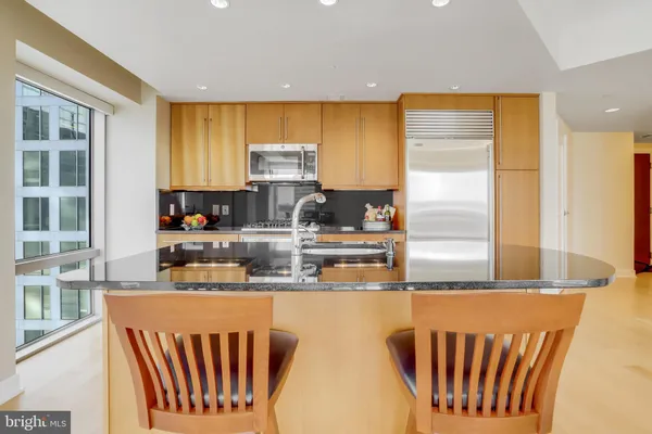 a kitchen with stainless steel appliances granite countertop a stove top oven a sink and a refrigerator