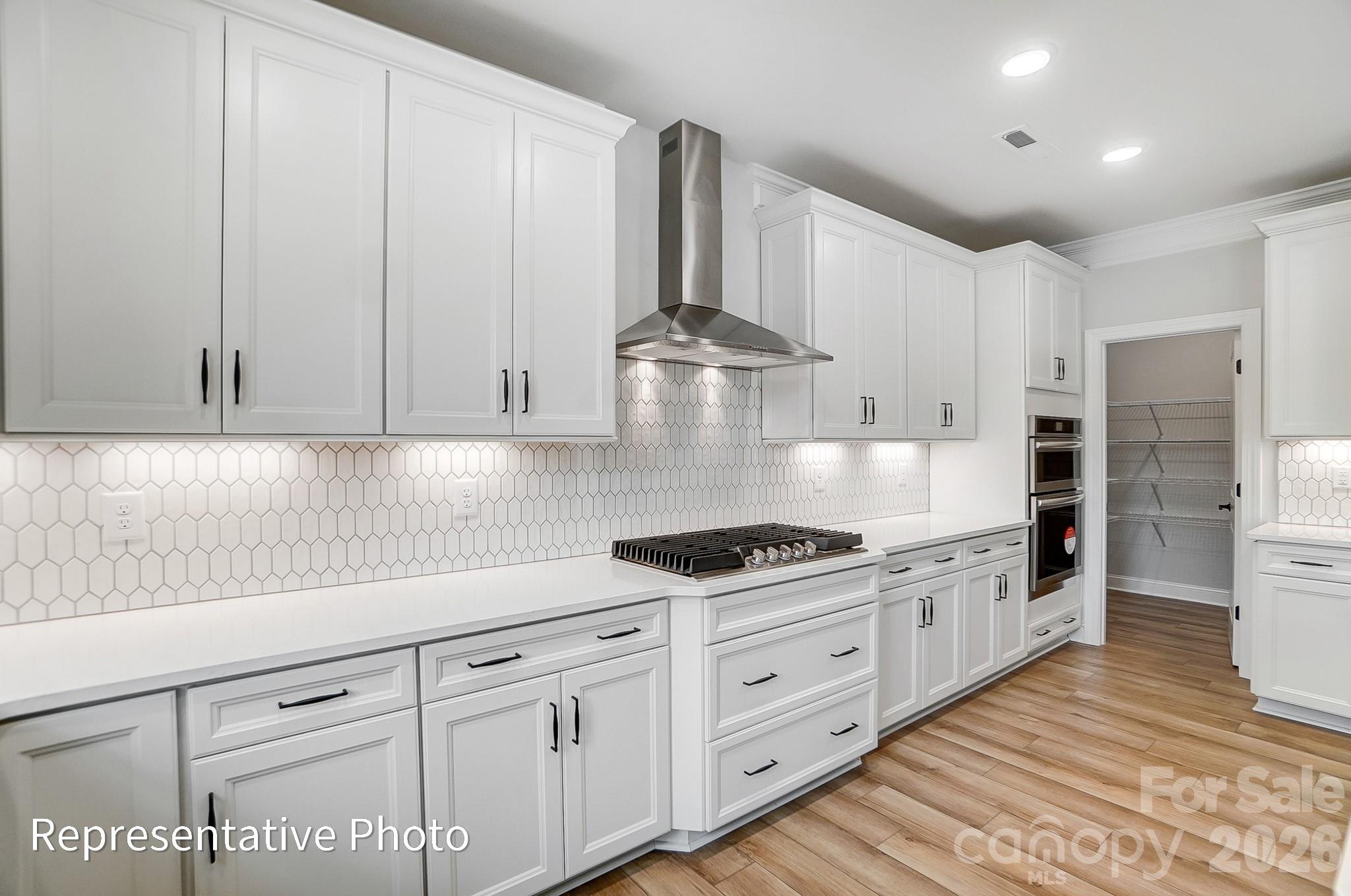 5058 Mclaughlin Loop Waxhaw, NC 28173 - Photo 22 of 42 a kitchen with granite countertop white cabinets and stainless steel appliances