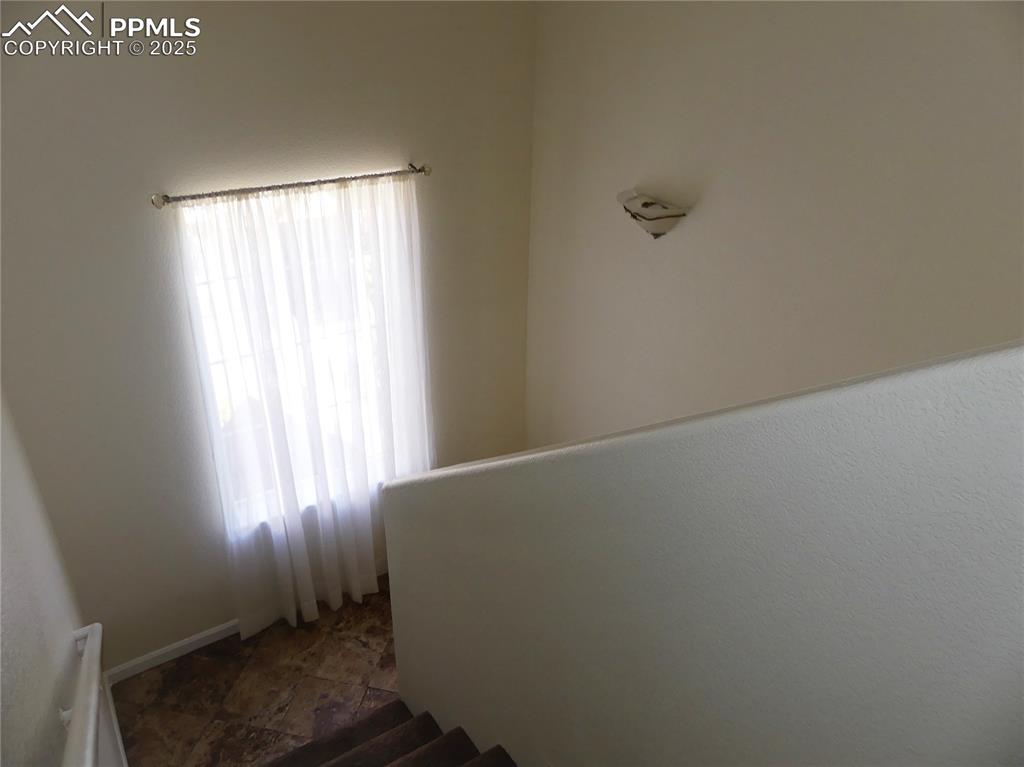 1054 Kara Ridge Point Colorado Springs, CO 80907 - Photo 26 of 33 Stairway featuring stone finish flooring