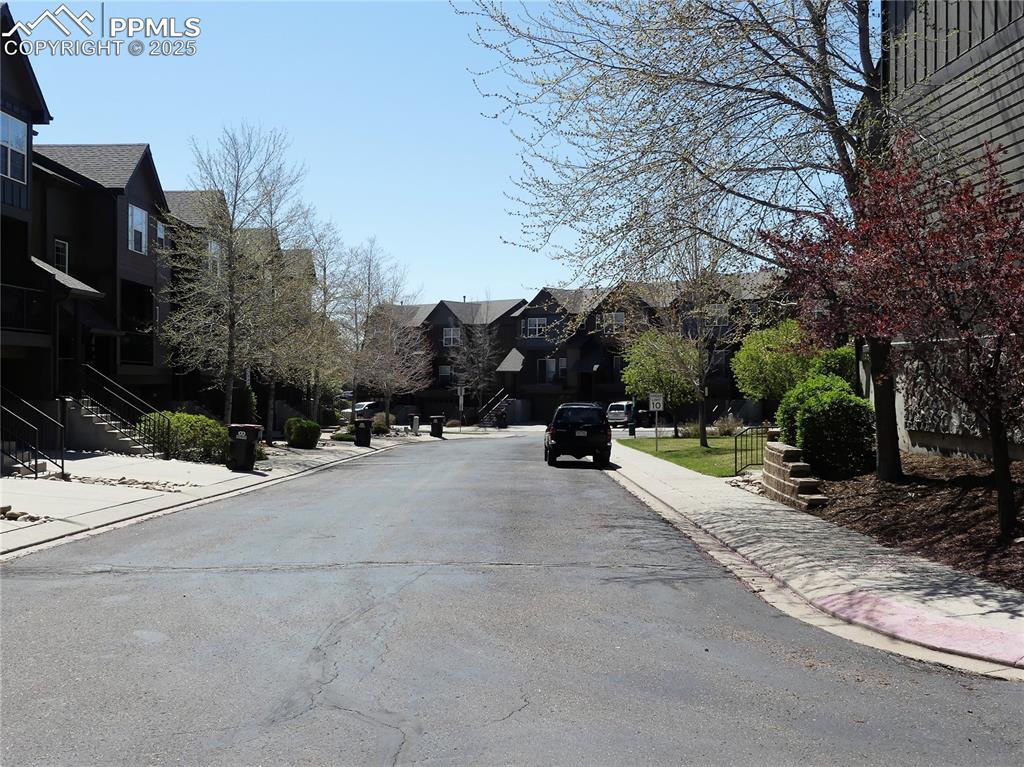 1054 Kara Ridge Point Colorado Springs, CO 80907 - Photo 29 of 33 View of road featuring curbs, stairway, sidewalks, and a residential view