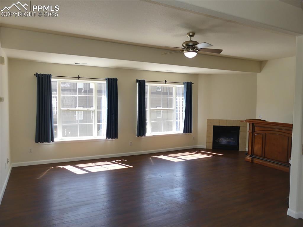 1054 Kara Ridge Point Colorado Springs, CO 80907 - Photo 4 of 33 Unfurnished living room with baseboards and wood finished floors